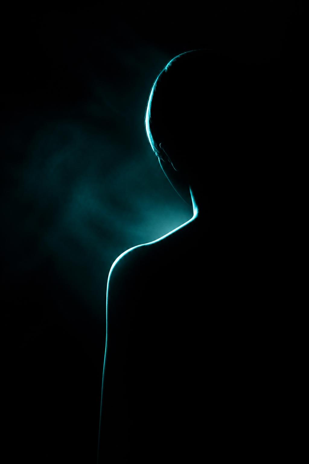 MorphME philosophy artwork — silhouette emerging from darkness in aqua light